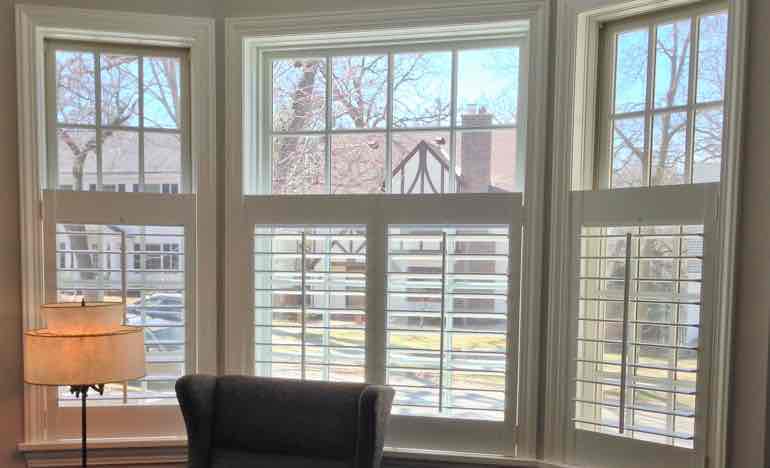 Half-length plantation shutters in den bay window.